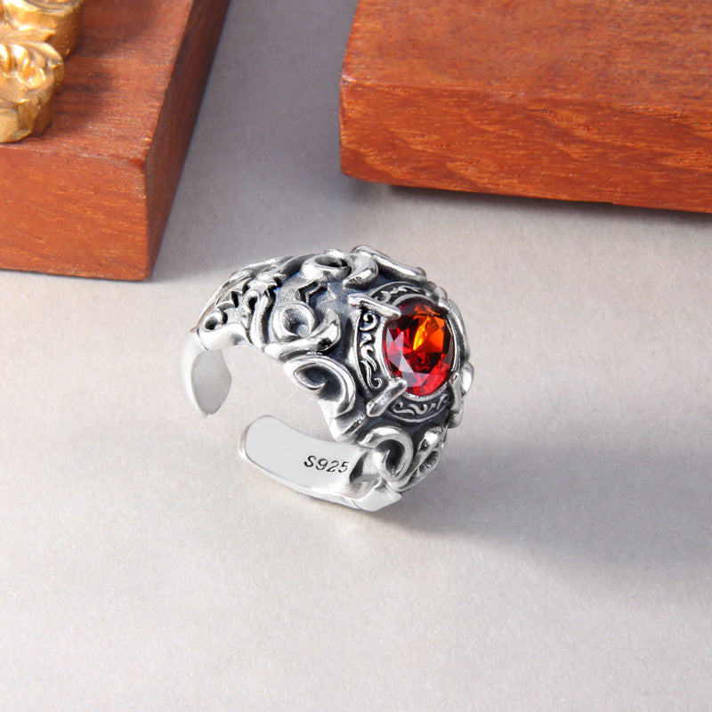 S925 sterling silver baroque ring on neutral surface showing ornate side profile, red zircon setting and intricate scroll patterns