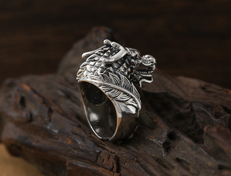 S925 sterling silver dragon ring on dark surface showing side profile, flowing mane detail and oxidized patina