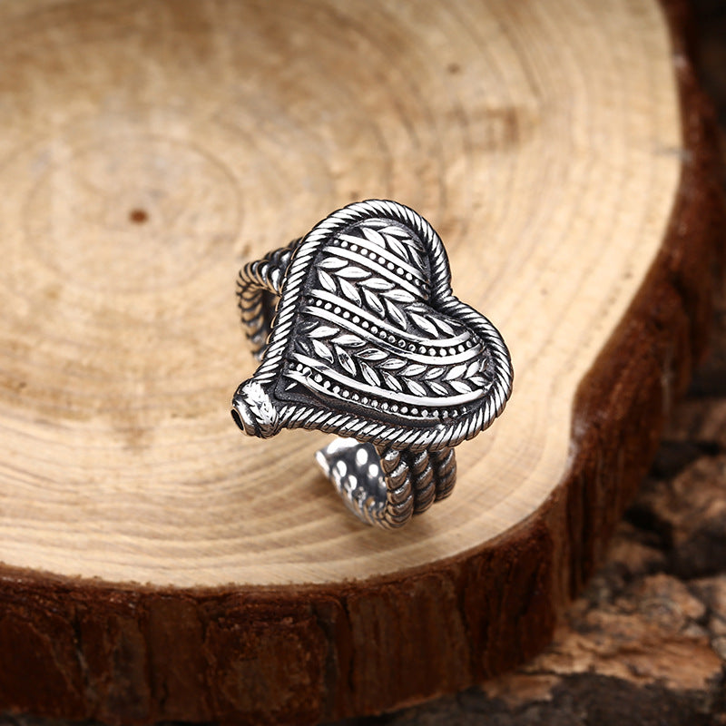 S925 sterling silver heart ring on wood surface showing side profile with detailed vine engraving