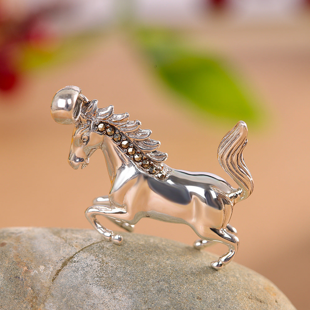 S925 sterling silver horse pendant on stone surface showing flowing mane detail, muscular form and oxidized accents
