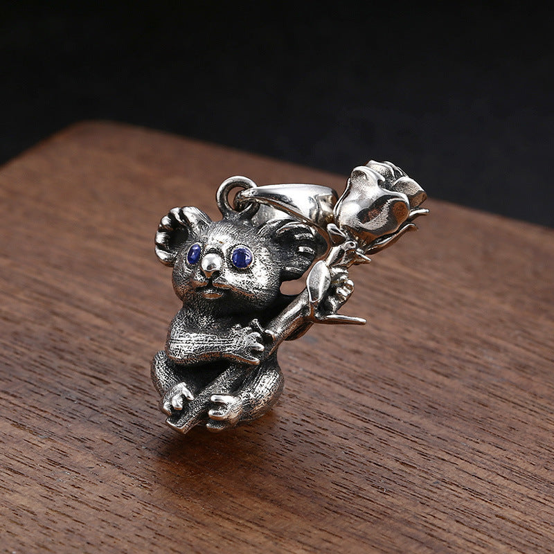 S925 sterling silver koala pendant on dark wood showing textured fur detail and oxidized accents