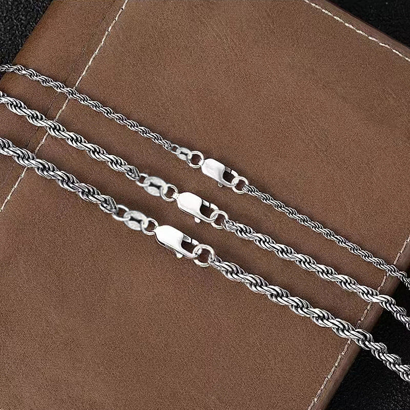 S925 sterling silver rope chain on brown surface showing lobster clasp, S925 stamp tag and twisted link detail