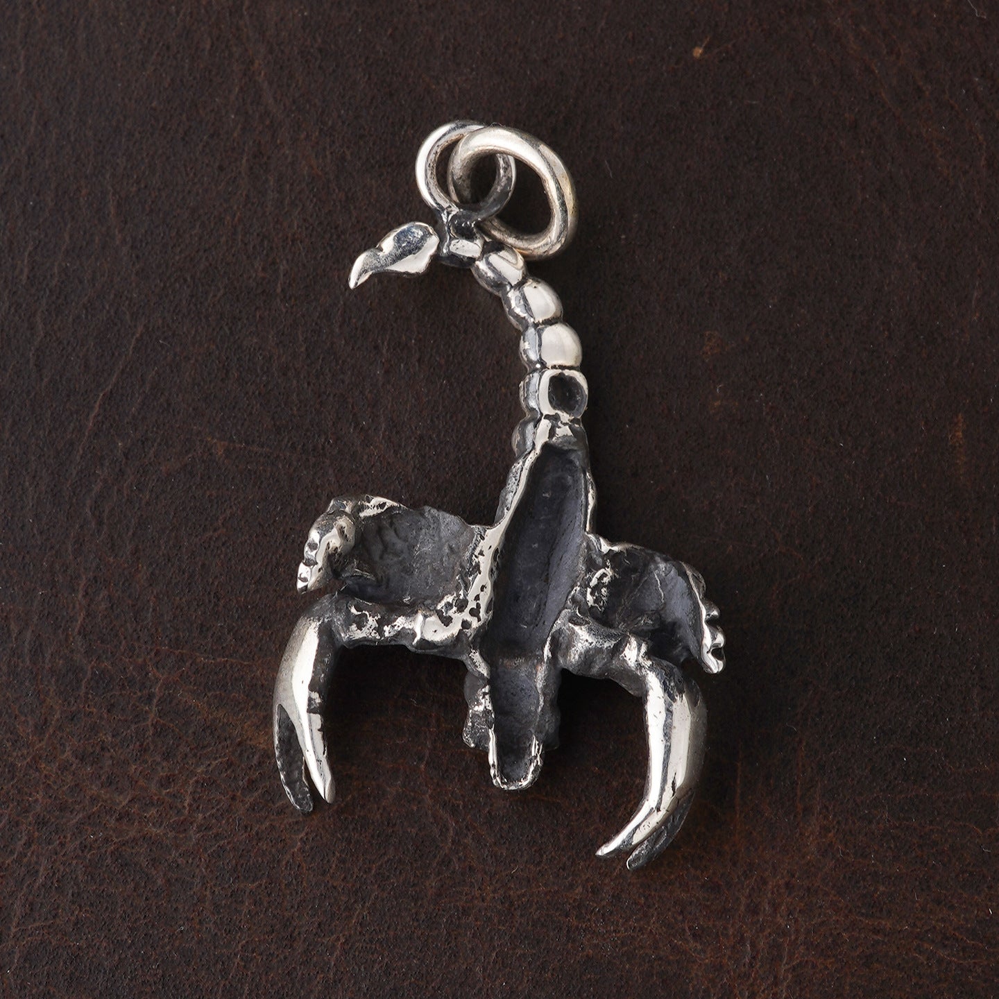 Underside view of S925 sterling silver scorpion pendant showing articulated segmented construction oxidized finish and dimensional craftsmanship
