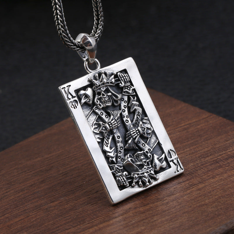 S925 sterling silver skeleton king pendant on dark surface showing intricate skull detail, playing card frame and gothic aesthetic