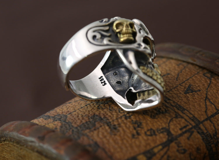 S925 sterling silver skull ring side view on wood showing brass crown skull, oxidized texture, and sterling band