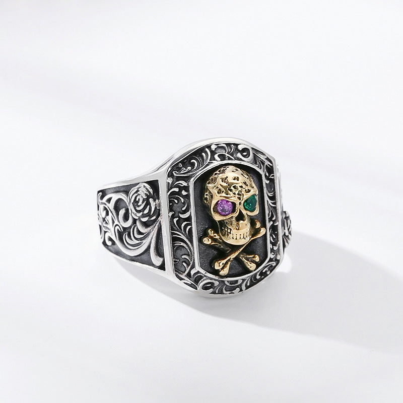 S925 sterling silver skull ring side view showing scrollwork band pattern and framed skull centerpiece