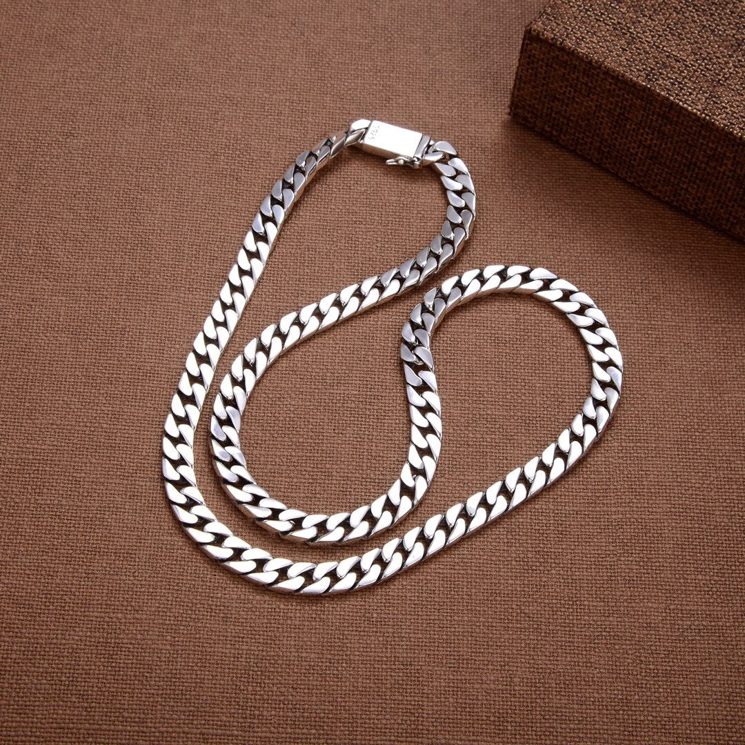 S925 sterling silver Cuban link chains in multiple lengths on wood surface showing oxidized finish