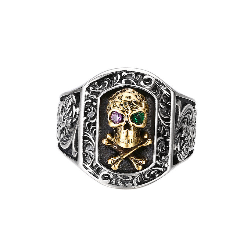 S925 sterling silver skull ring on white background showing gold-tone skull with gemstone eyes and baroque frame detail