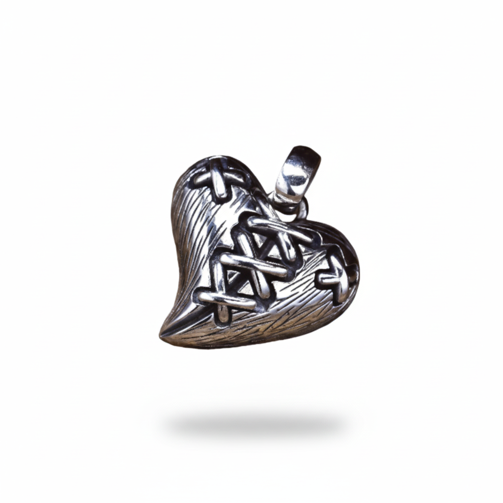 S925 sterling silver stitched broken heart pendant on wood surface showing dimensional lacing detail, textured grooves and oxidized finish