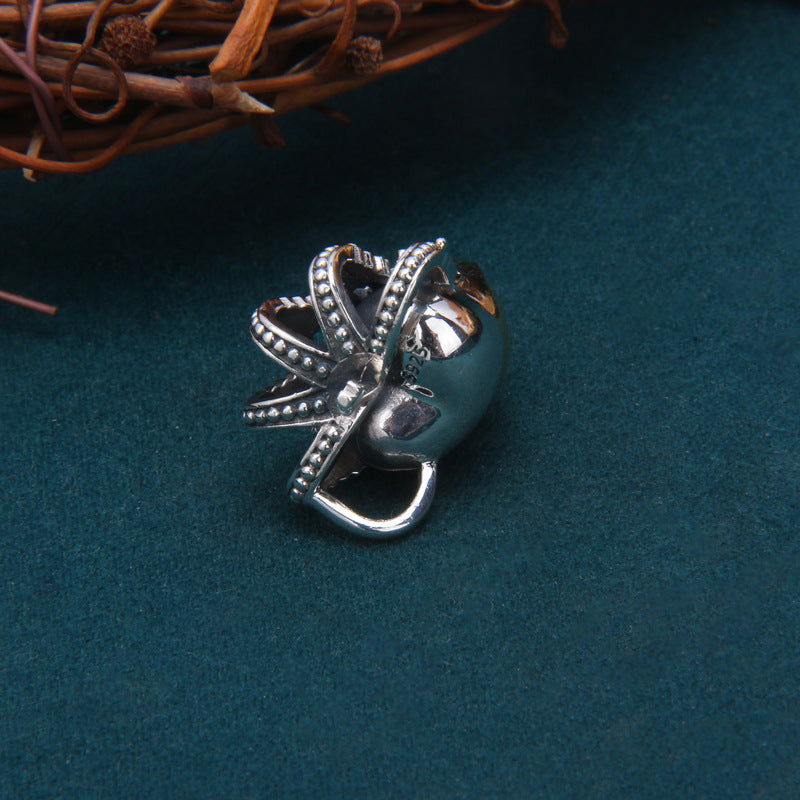 Side profile of S925 sterling silver crown skull pendant on dark background showing dimensional detail and brass sku