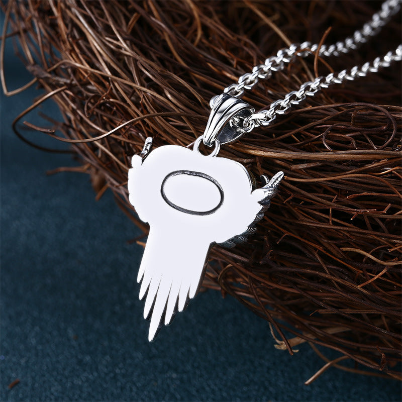 S925 sterling silver winged heart pendant back view on wood showing halo detail, wing structure, and polished finish