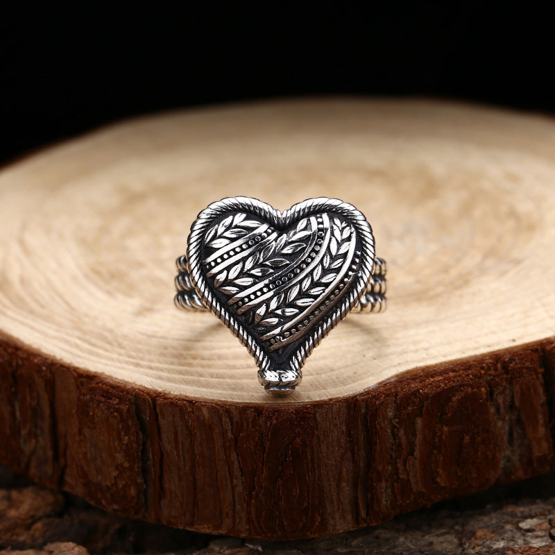 S925 sterling silver adjustable heart ring on wood showing dimensional vine texture and oxidized finish