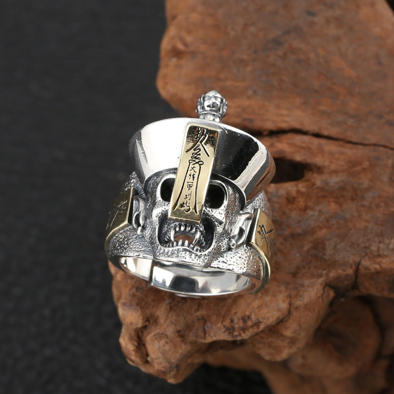 S925 sterling silver samurai skull ring on dark stone showing textured helmet gold accents and gothic style