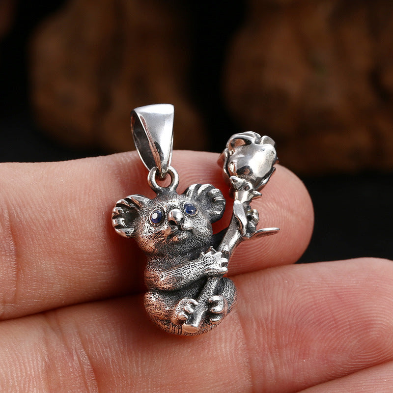 S925 sterling silver koala pendant held in hand showing dimensional sculpting and rose detail