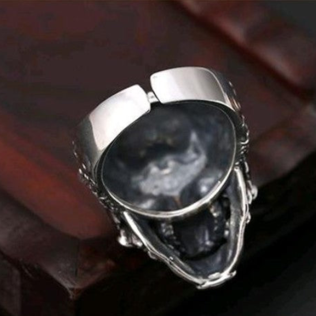 Sterling silver necromancer skull ring interior view on dark surface showing adjustable open band design