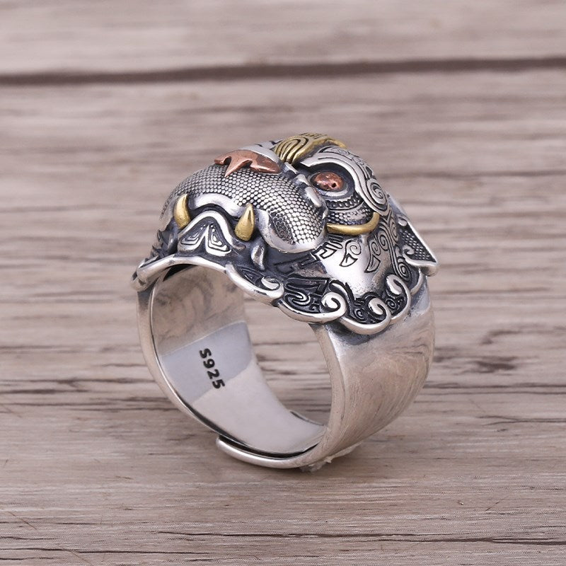 Sterling silver Pixiu ring on wood surface showing side profile, S925 hallmark stamp and brass eye detail