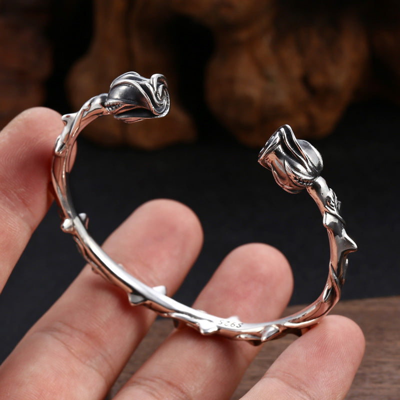 Close-up of S925 sterling silver rose bracelet in hand showing thorn detail and sculptural floral craftsmanship