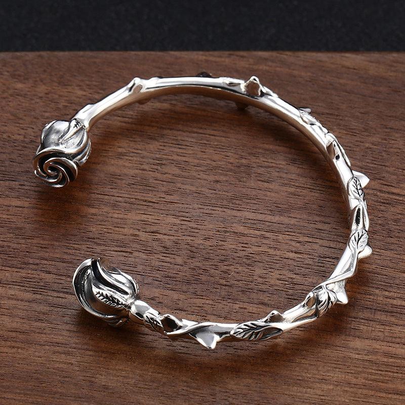 S925 sterling silver rose bangle 58mm diameter displayed on wood showing floral sculptural design