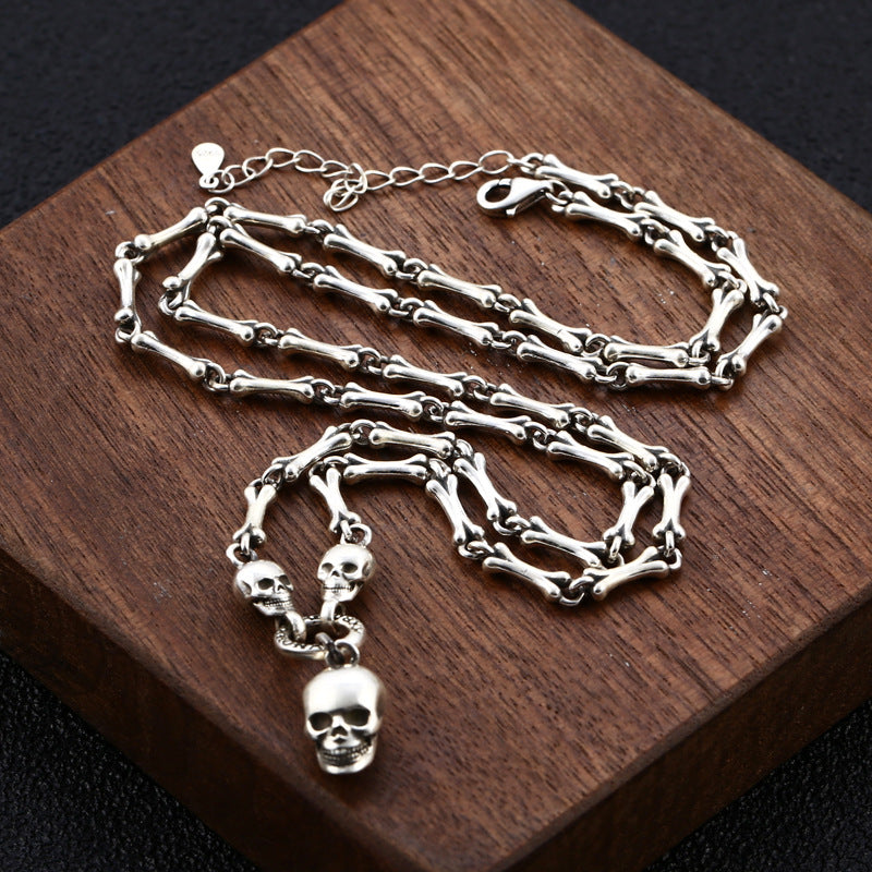 S925 sterling silver skull bone chain necklace on wood surface showing 3mm gothic link design and skull pendant