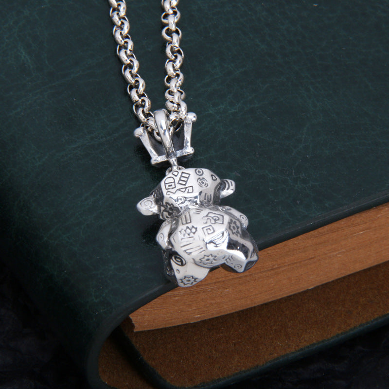 Back profile of S925 sterling silver Thai bear charm on chain showing graffiti lettering oxidized finish and authentic weight