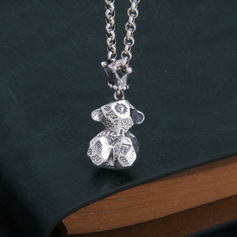 S925 sterling silver Thai bear charm on chain showing graffiti lettering detail and dimensional craftsmanship on dark surface