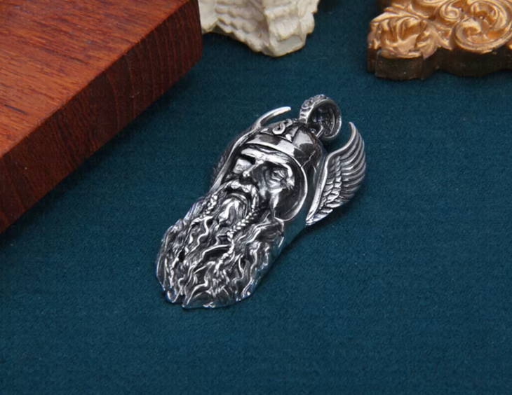 Side profile view of the Viking warrior pendant placed on a textured teal surface beside wooden décor.
