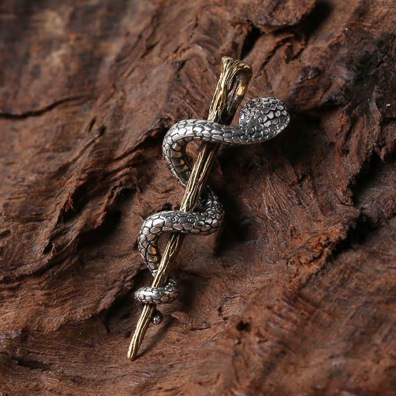 S925 sterling silver serpent staff pendant with red zircon displayed on bark showing healing transformation symbolism