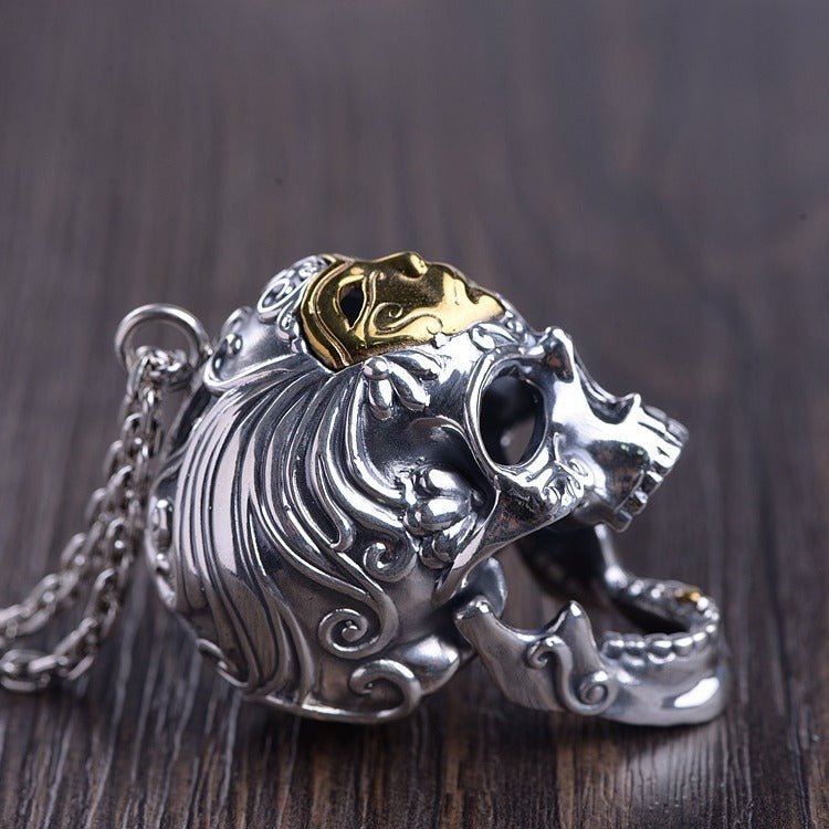 Side-back view of the skull pendant with chain visible, focusing on the sculpted hair pattern and polished gold topper.