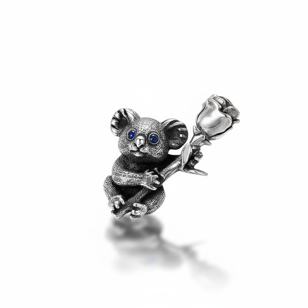 S925 sterling silver koala rose pendant on white background showing detailed koala with rose flower and blue gemstone accent, polished finish, and natural shadow